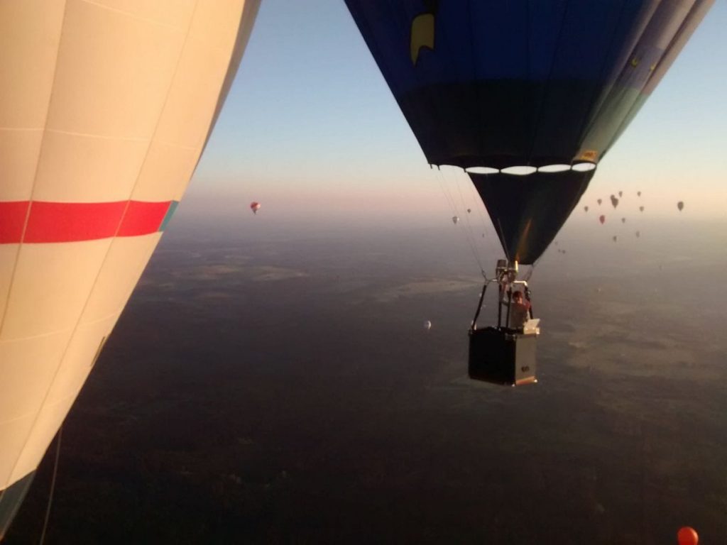 Luchtballon stijgt op durante ballonvlucht met passagiers, ervaar de vrijheid hoog in de lucht