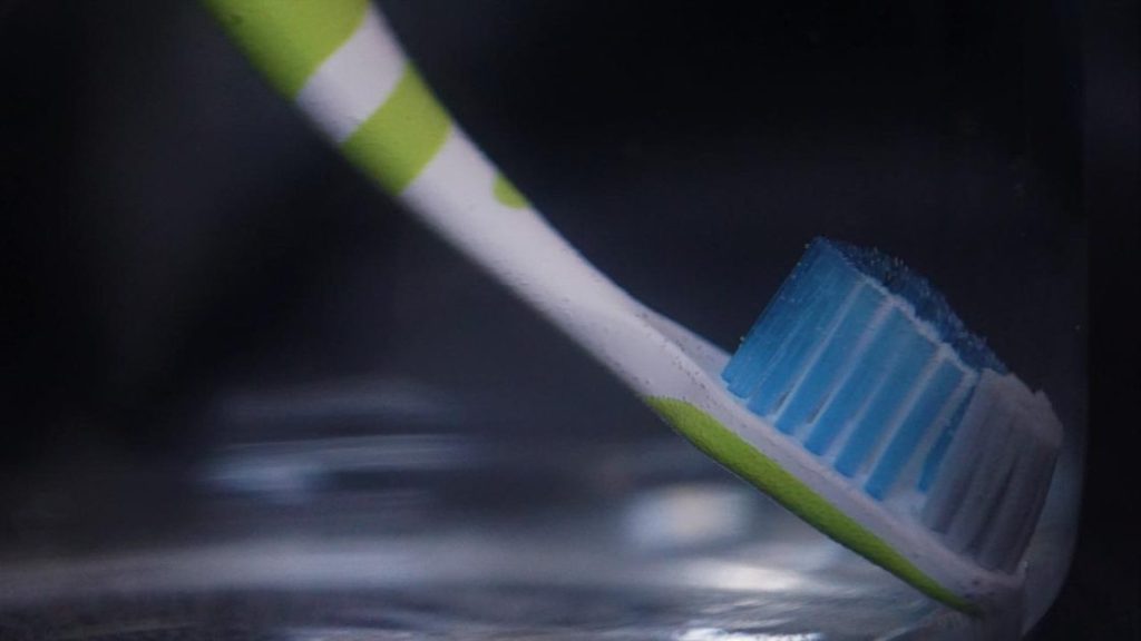 Afbeelding over beste mondhygiëne tips: tandenpoetsen met tandenborstel en tandenrager
