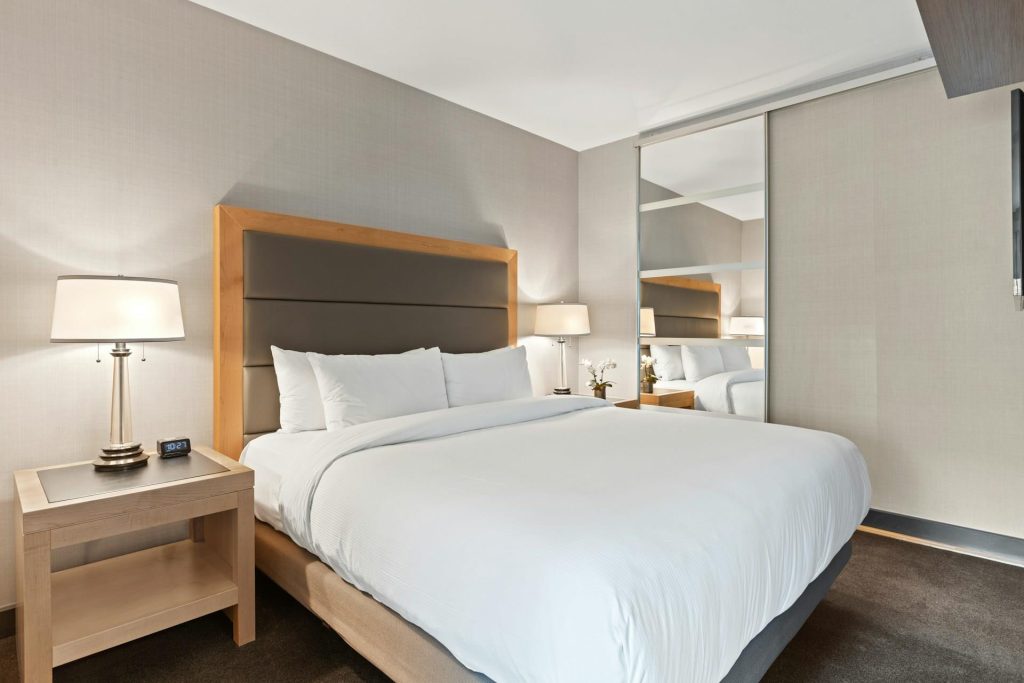 Mooi opgemaakt bed met een perfect dekbedovertrek in neutrale tinten in een modern ingerichte slaapkamer