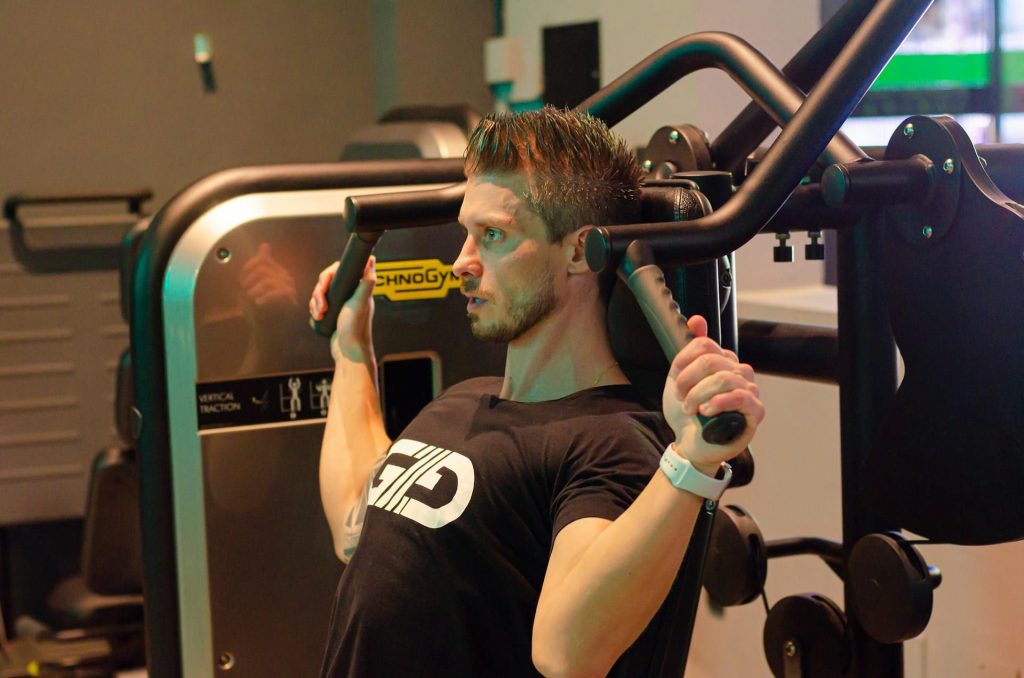 Man die thuis sporten beoefent met dumbbells in een huiskamer voor effectieve thuistraining